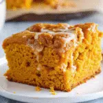 Pumpkin Earthquake Cake 5 Golden pumpkin earthquake cake with swirled cream cheese, chocolate chips, and pecans showing characteristic cracked surface pattern in a white baking dish