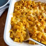 Creamy Butternut Squash Mac and Cheese 5 Creamy butternut squash mac and cheese in a white baking dish, topped with golden melted cheese and garnished with fresh chives