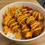 Easy Bang Bang Chicken Bowl 8 Colorful Bang Bang Chicken Bowl with golden seasoned chicken pieces, fresh vegetables, and creamy sauce served over white rice