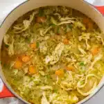 Easy Chicken and Rice Soup 8 A steaming bowl of homemade chicken and rice soup with tender vegetables and shredded chicken in a rich, golden broth, garnished with fresh parsley