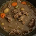 Crock Pot Beef Stew 5 A hearty bowl of Crock Pot Beef Stew with tender chunks of meat, colorful vegetables, and rich brown gravy, served with crusty bread