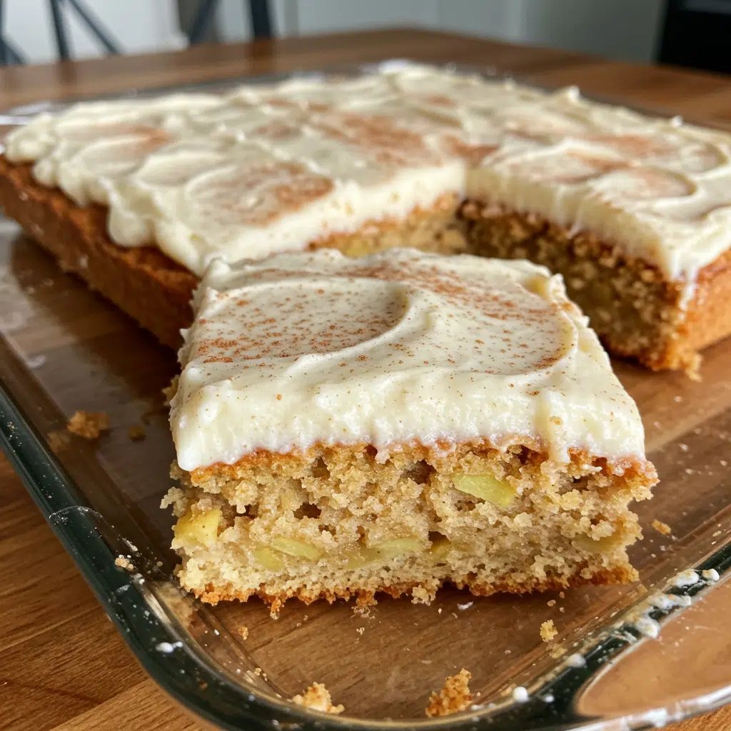 Golden brown apple cinnamon sheet cake in a 9x13 baking pan, topped with glazed apple slices and drizzled with white icing