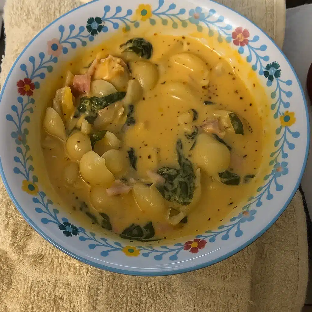 Creamy Marry Me Chicken Soup with shell pasta, spinach, and sun-dried tomatoes in a white bowl
