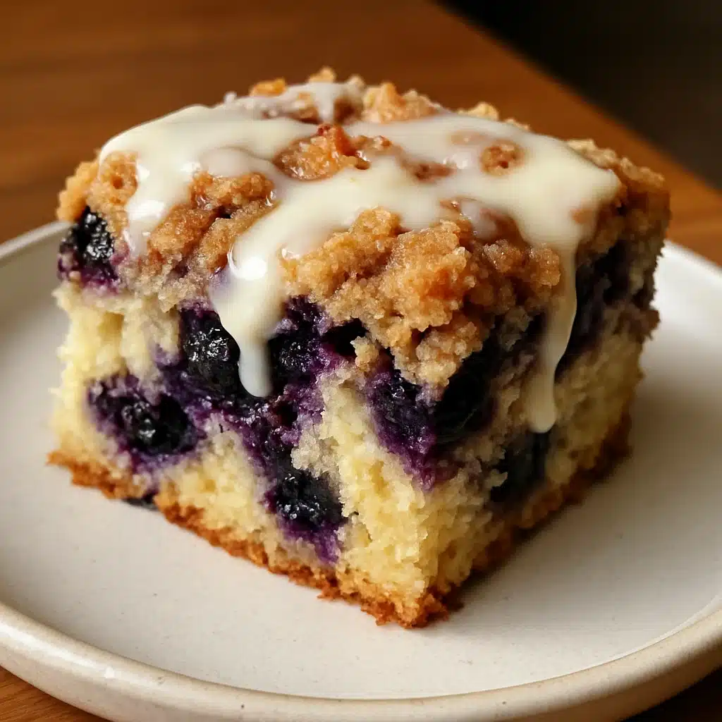 Messy slice of blueberry coffee cake with crumbly topping and berries falling out