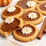 Soft pumpkin pie cookies topped with creamy spiced frosting and a sprinkle of cinnamon.