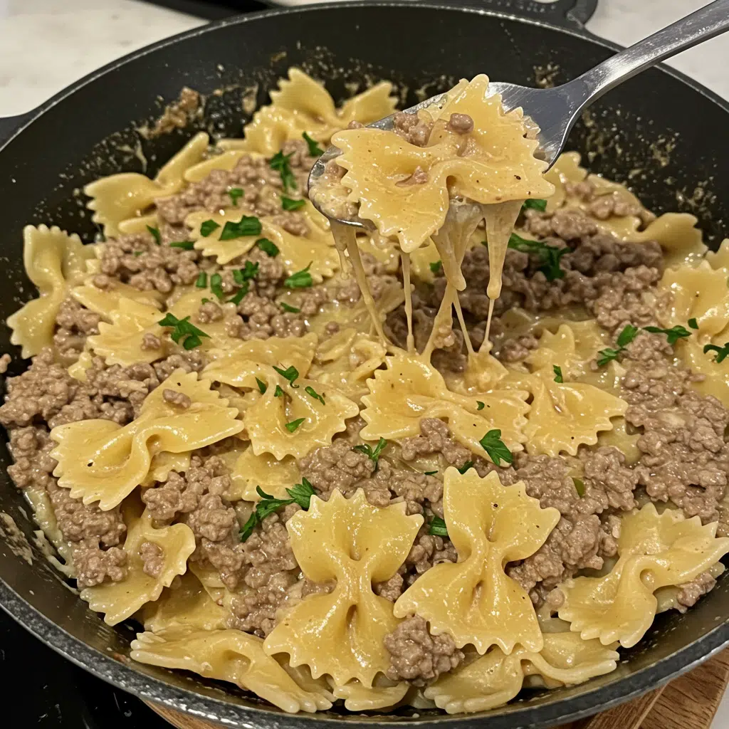 Creamy bowtie pasta with ground beef in a skillet topped with melted cheddar cheese and fresh parsley