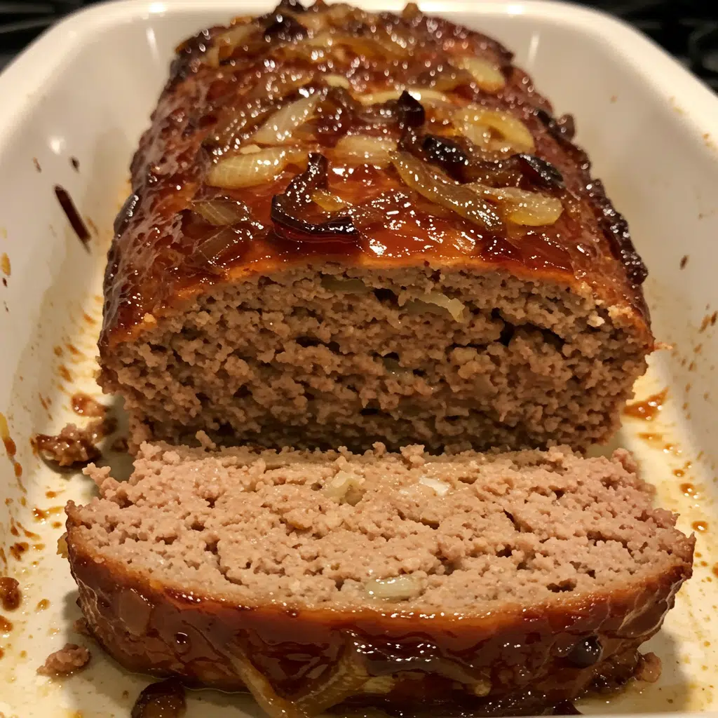 Sliced French onion meatloaf on a white serving platter with caramelized ketchup glaze on top, garnished with fresh parsley