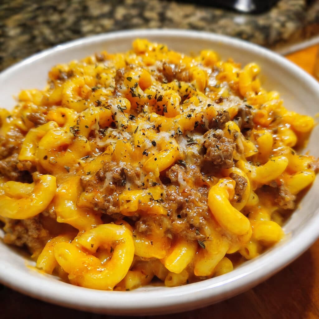Creamy homemade hamburger helper in a large skillet with melted cheddar cheese and elbow macaroni pasta with ground beef