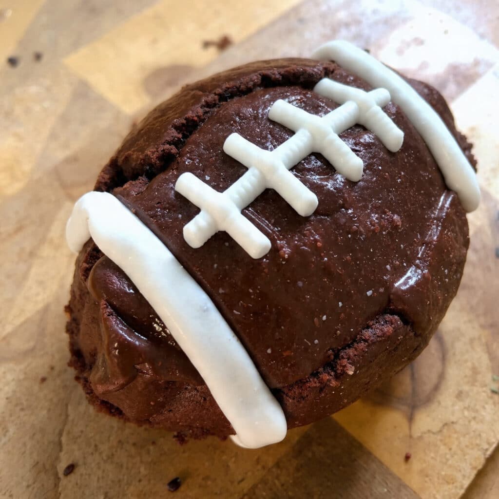 Rich fudgy football brownies decorated with white icing to look like football laces, arranged on a platter for a fun game-day treat.