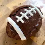 Rich fudgy football brownies decorated with white icing to look like football laces, arranged on a platter for a fun game-day treat.