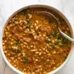 Southern Black Eyed Peas with smoky bacon, savory sausage, and tender greens – the ultimate comfort food