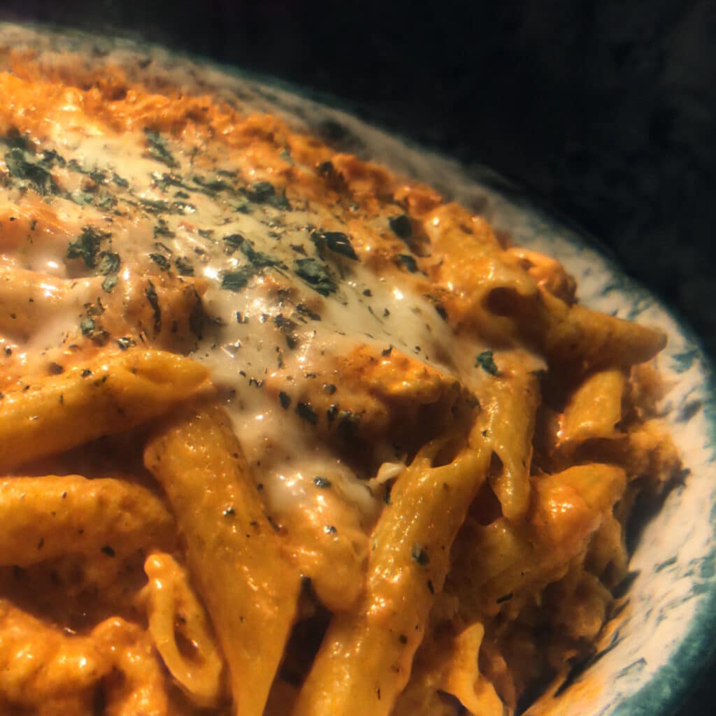 Buffalo Chicken Pasta coated in creamy buffalo sauce and topped with cheese and green onions.