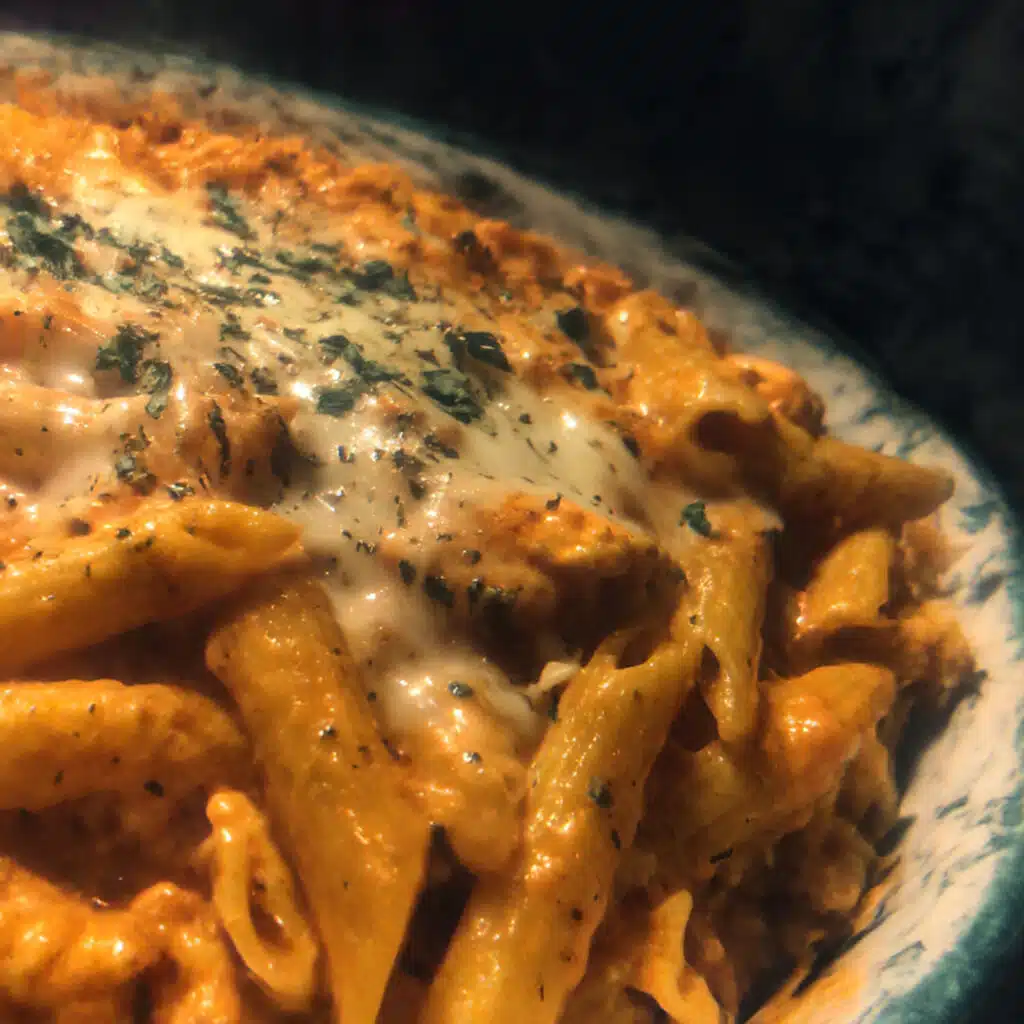 Buffalo Chicken Pasta coated in creamy buffalo sauce and topped with cheese and green onions.