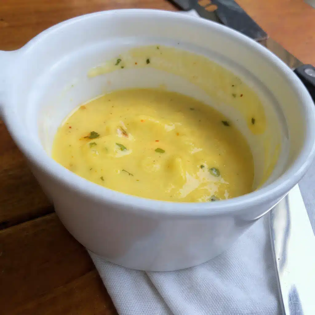 Silky lemon butter sauce poured over a dish and garnished with fresh lemon zest