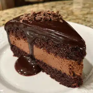 Chocolate mousse cake with layers of rich chocolate mousse and moist chocolate cake, topped with glossy chocolate ganache.