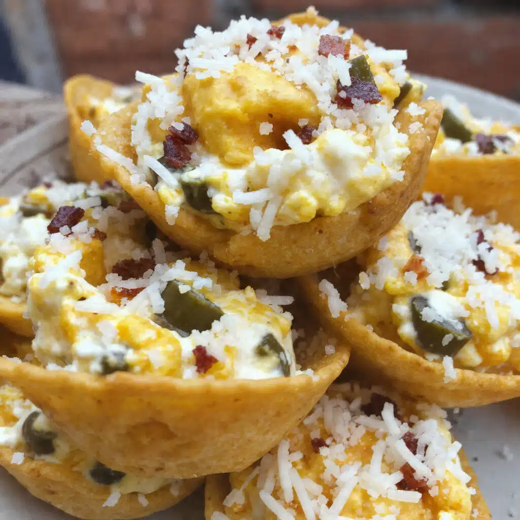 Golden-brown Playoff Puffs arranged on a white platter, featuring Tostitos Scoops filled with creamy jalapeño-bacon mixture topped with melted Parmesan cheese