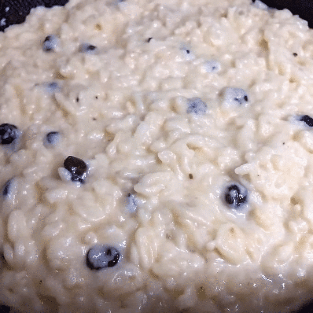 A bowl of creamy homemade rice pudding with golden raisins, garnished with a sprinkle of cinnamon on top