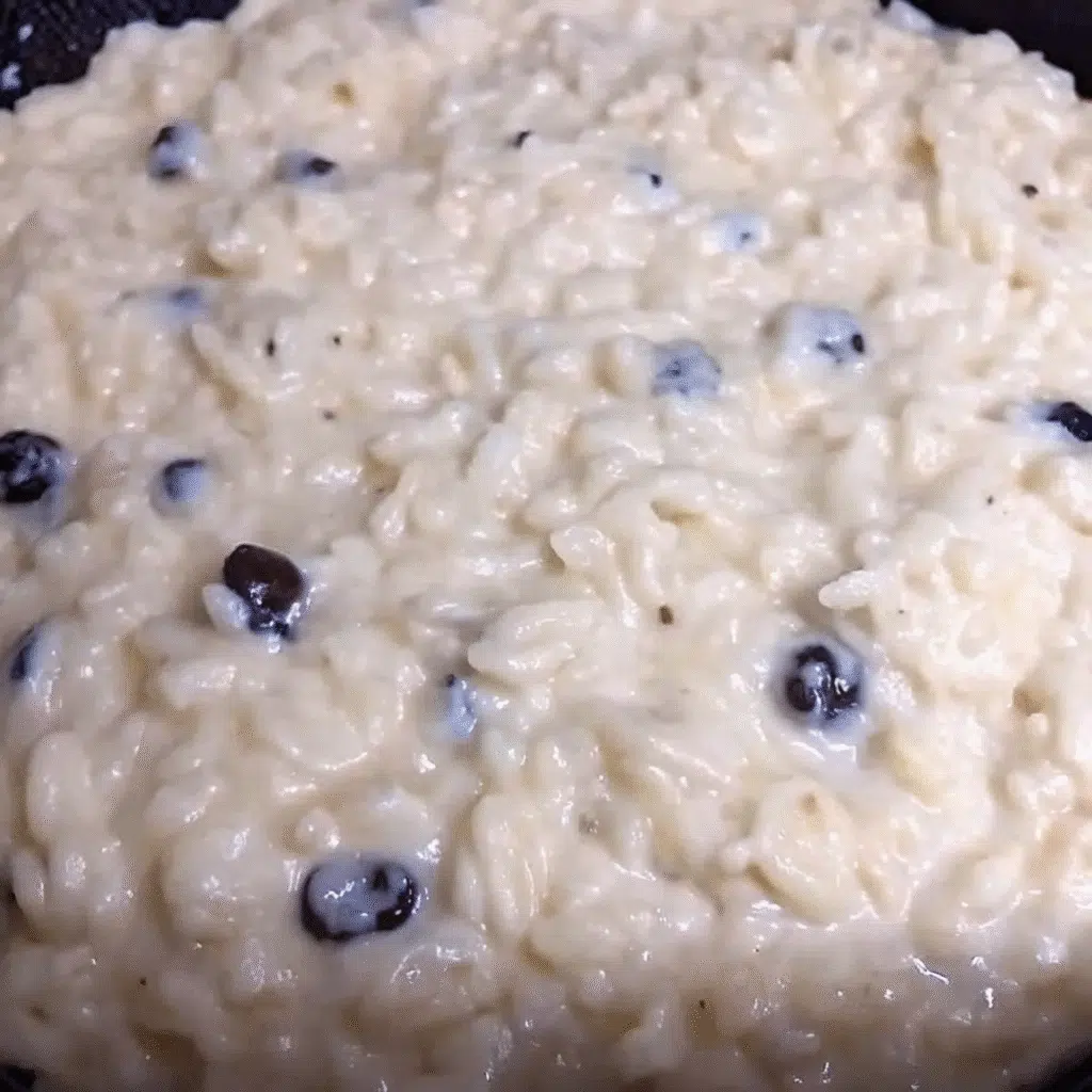 The Best Creamy Rice Pudding 6 A bowl of creamy homemade rice pudding with golden raisins, garnished with a sprinkle of cinnamon on top