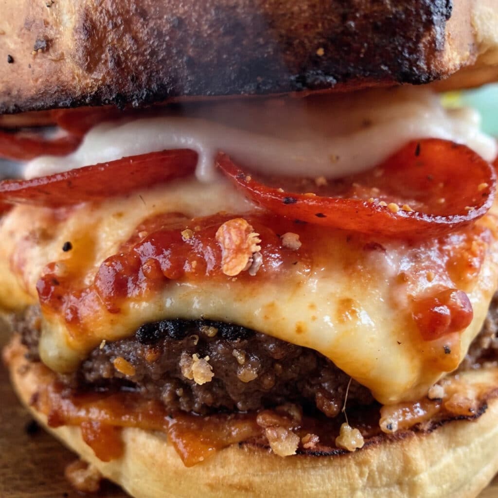 Juicy pizza burger on a toasted bun topped with melted mozzarella cheese, pepperoni slices, and pizza sauce