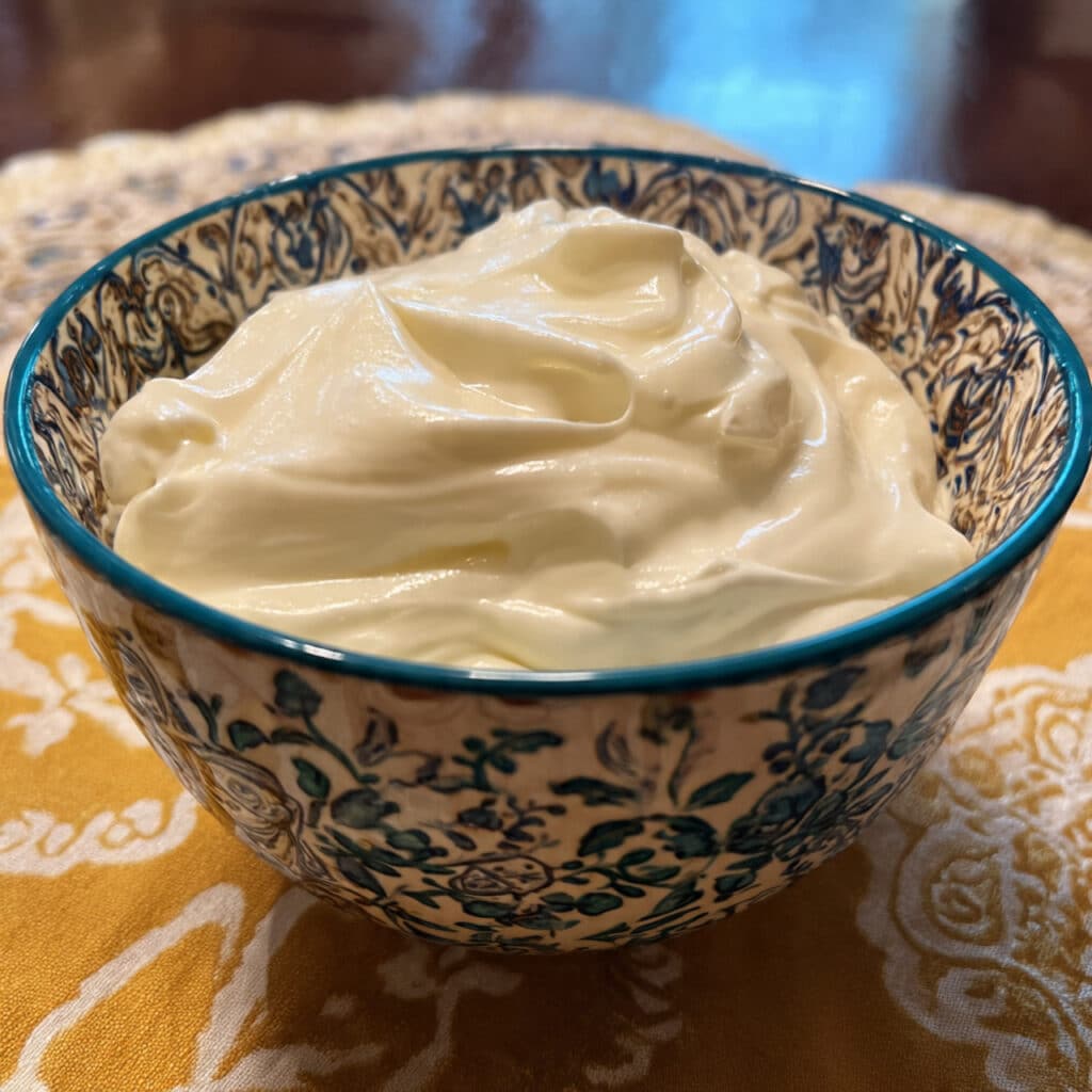 creamy homemade Greek yogurt in a white bowl with a spoon, showing smooth velvety texture