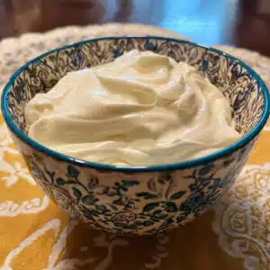 creamy homemade Greek yogurt in a white bowl with a spoon, showing smooth velvety texture