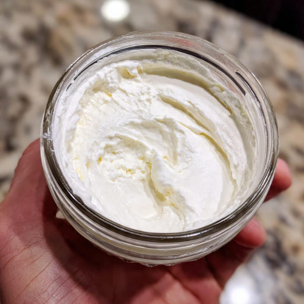 creamy homemade Greek yogurt in a white bowl with a spoon, showing smooth velvety texture