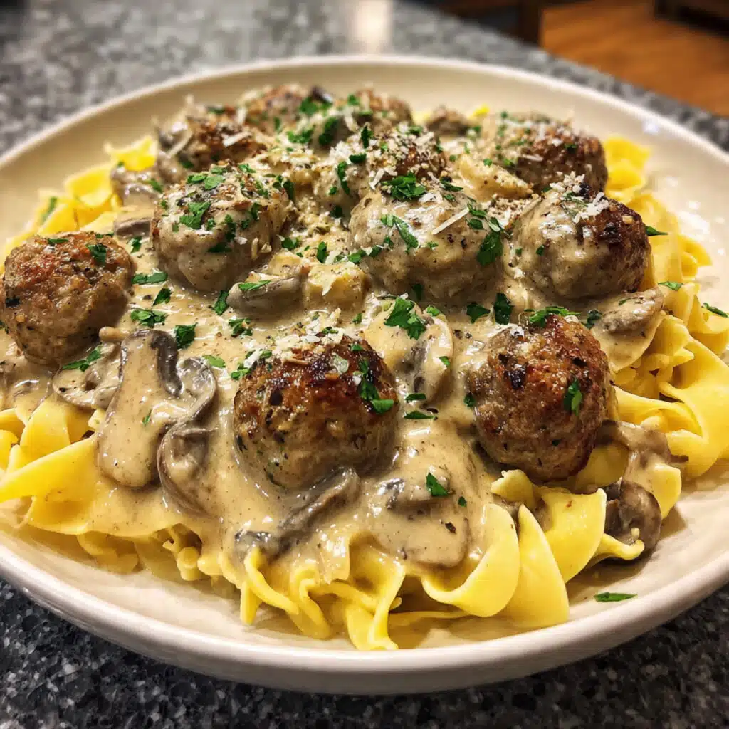 Creamy meatball stroganoff served over egg noodles in a white bowl, garnished with fresh parsley, showing tender meatballs coated in rich mushroom sauce